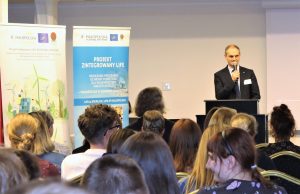 Mężczyzna przemawia na tle rollapów projektów LIFE