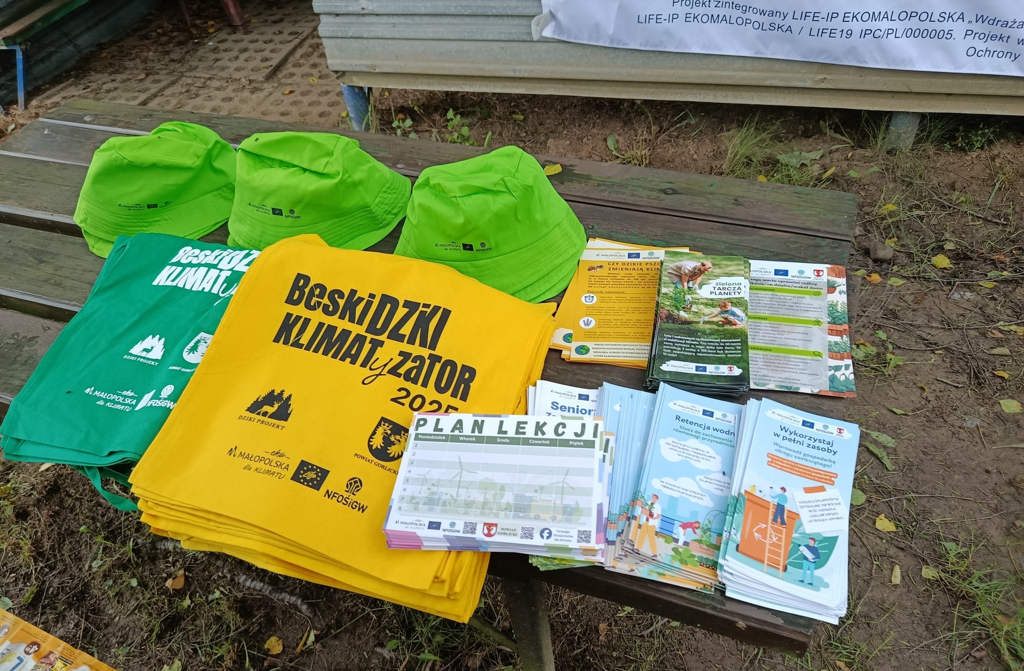 czapki, bawełniane torby i ulotki o zmianie klimatu rozłożone na stoisku