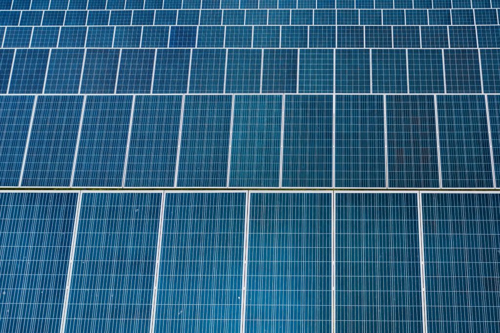 Zdjęcie przedstawia liczne panele fotowoltaiczne w kolorze niebieskim